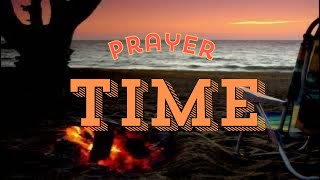 Prayer time on the beach with a beautiful sunset and campfire.