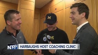 Jim and John Harbaugh jab at each other in conversation with Brad Galli at Michigan Coaching Clinic