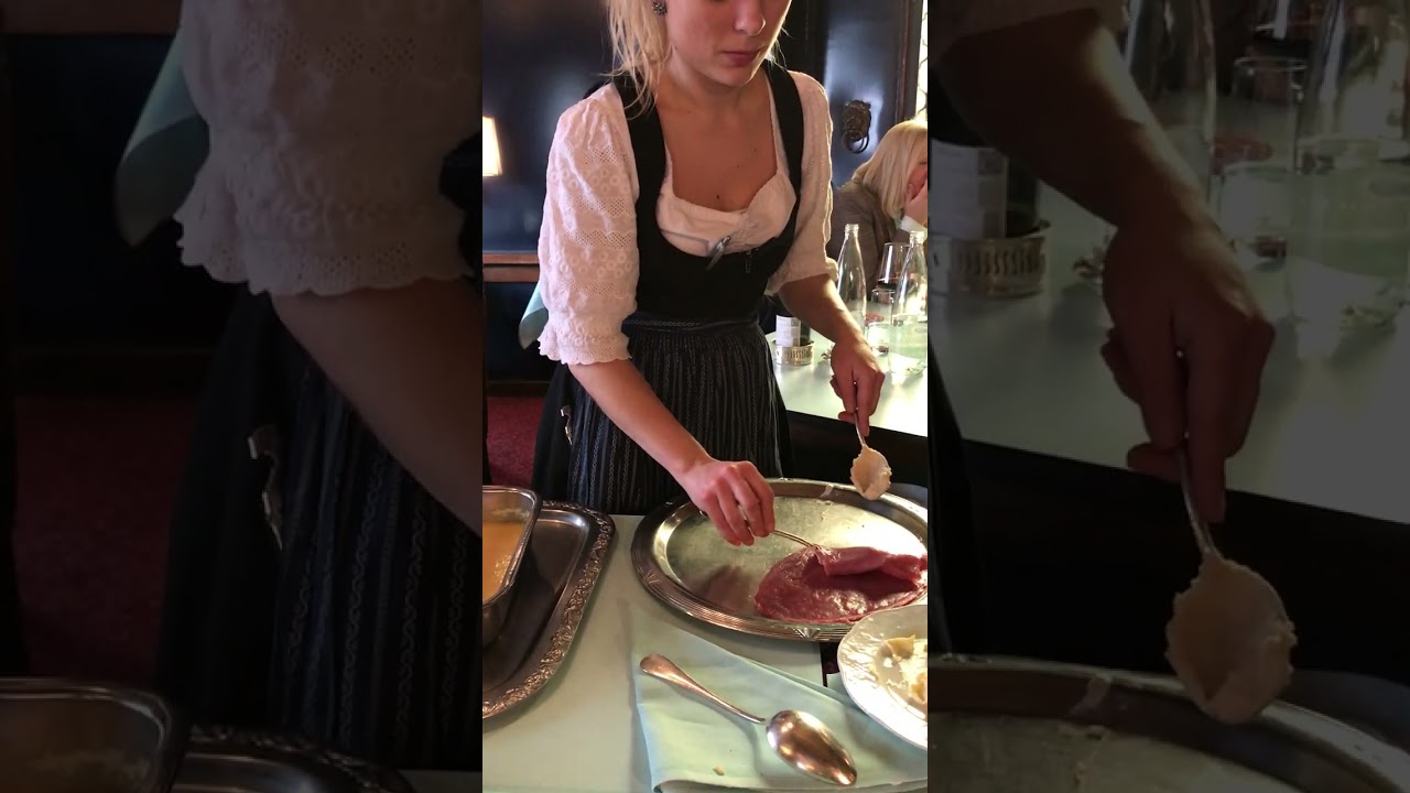 Restaurant goers watch as schnitzel is being prepared at their table in Switzerland