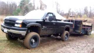 Lifted Duramax pulling dump trailer out of mud