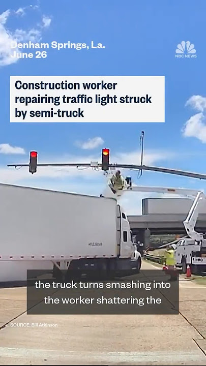 Construction worker repairing traffic light struck by semi-truck