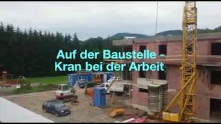 Auf der Baustelle/Kran bei der Arbeit/Wohnanlage wird gebaut