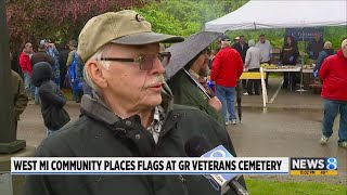 Volunteers place flags on gravesites to honor veterans