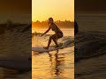 She doesn’t chase waves—she dances with them 夕暮れの光の中で穏やかな波に乗る美女