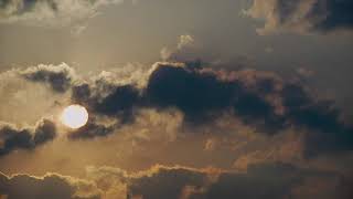 Dark clouds passing the sun (playback video)