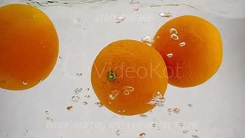 The orange falling in water with bubbles. Video in slow motion. Fruits on isolated a white