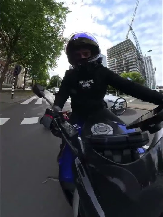 Woman on bicycle falls after crossing red light in front of motorcycle in Rotterdam, Netherlands