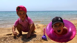 Малыш и сонная мама играют на пляже в песке. Видео для детей