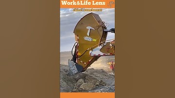 The video shows a rock breaker with a chisel attachment, breaking large rocks for construction work.