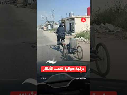رجل يقود دراجة هوائية بثلاث عجلات ومقود دائري تثير فضول المارّة في ريف حماة