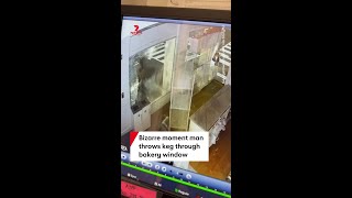 Bizarre moment man throws keg through bakery window