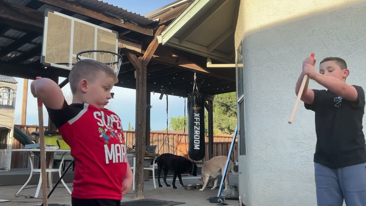 Oliver and Jack beating up cardboard. 