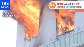 住宅から立ち上る炎と煙 消防隊が８０代女性を救助