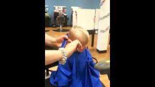 Baby laughing during first haircut.