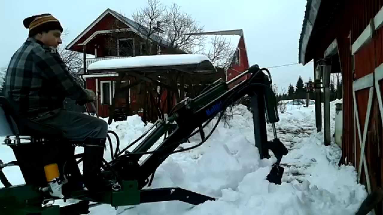Towable miniexcavator remowing heavy snow, Minikaivuri Kellfri lumen luontia