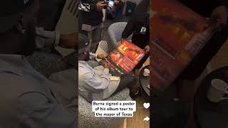 Burna did signing of his album poster to the mayor of Texas