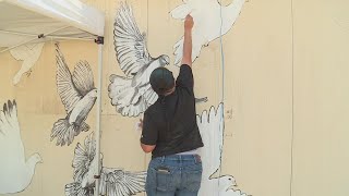 Child helps paint mural honoring the victims of the Uvalde shooting