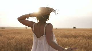 Молодая женщина бежит по пшеничному полю, держа в руках соломенную шляпу. Footage. Футаж.