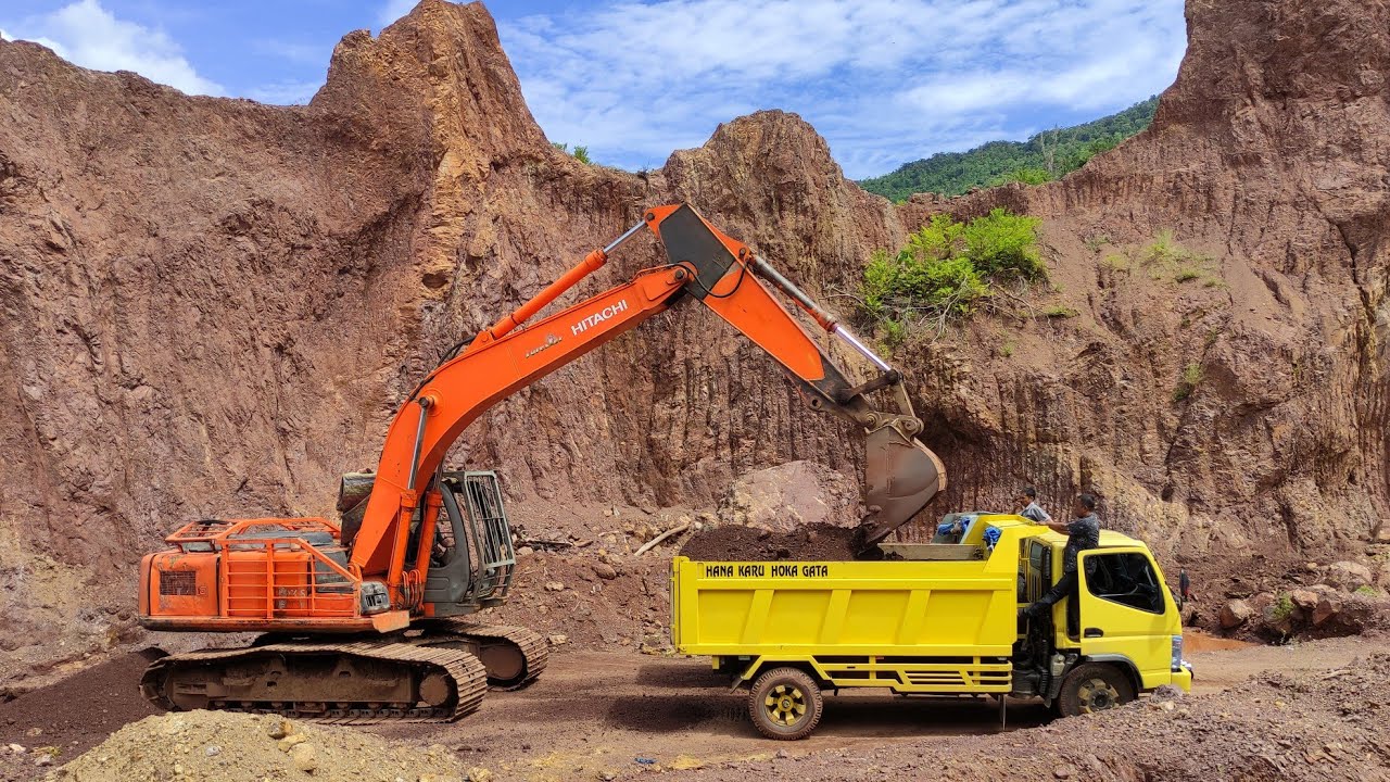 Beko keruk  tanah  dan mobil  truk bekerja mengangkut tanah  