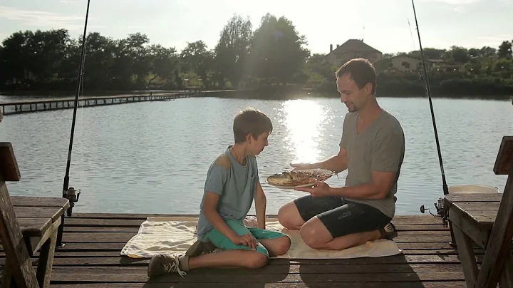 handsome boy enjoying aroma of fried fish on lake