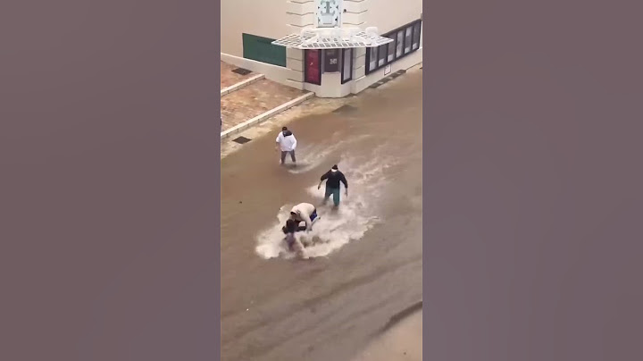 DANA EN MÁLAGA: dos hombres levantan a una mujer arrastrada por el agua en el centro de la ciudad