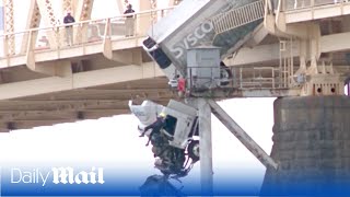 Moment firefighter rescues driver from dangling wrecked truck