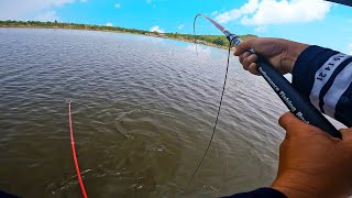 Young man fishing on a boat in the middle of the water