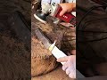 Hand polishing knife blade using electric buffing wheel.