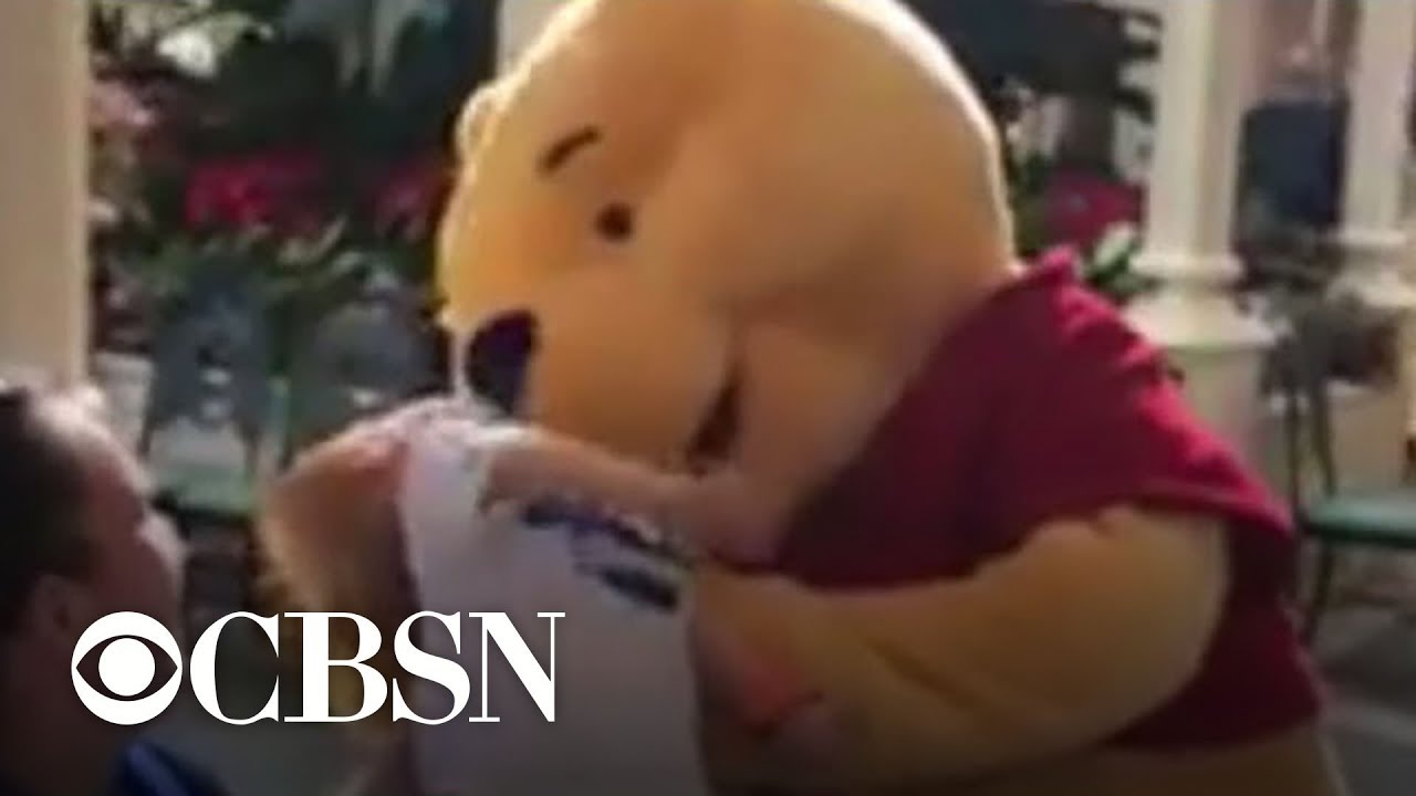 Child with special needs comforted by Winnie the Pooh at Disney World