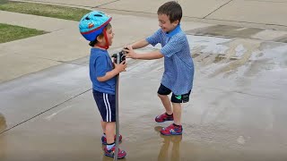 Little Brother Sprays Big Brother with the Garden Hose