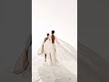 Full-body shot of male and female models walking across a vast white desert made of powder, futur...