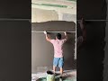 leveling out the gray cement mixture on the large wall area for an even finish