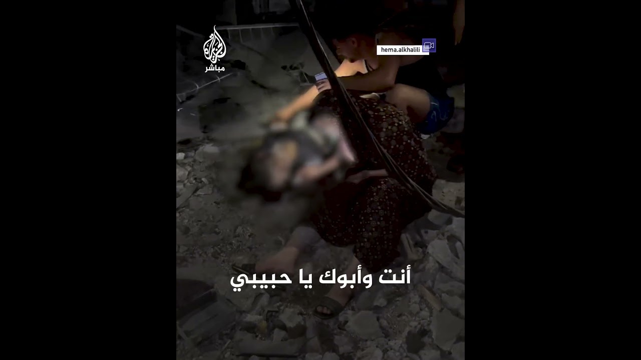 ممسكة بيده وهو يرفع السبابة.. أم مكلومة تجلس بجوار نجلها الذي استشهد في قصف إسرائيلي على قطاع غزة
