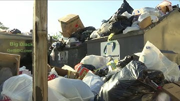 Trash overflowing apartment complex dumpsters