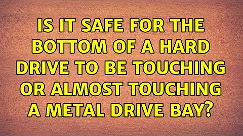 Is it safe for the bottom of a hard drive to be touching or almost touching a metal drive bay?