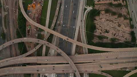 Aerial birds eye overhead top down panning view of large and complex multilane highway intersection