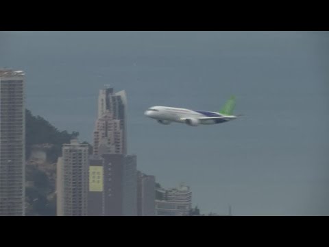 China's homegrown C919 aircraft flies over Hong Kong harbour