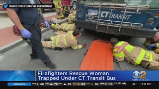 Firefighters lift bus off woman trapped below