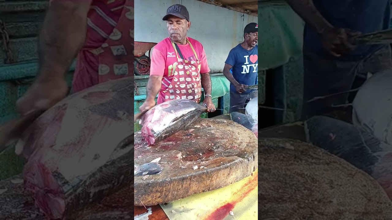 Uncle Yakop's sturdy hands in action cutting a large whole tuna  