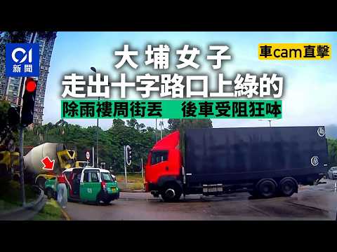 【01秒看新聞】車Cam｜大埔女子十字路口上的士　雨褸丟地　後車受阻狂呠｜01新聞｜車Cam｜大埔｜十字路口｜上的士｜雨褸