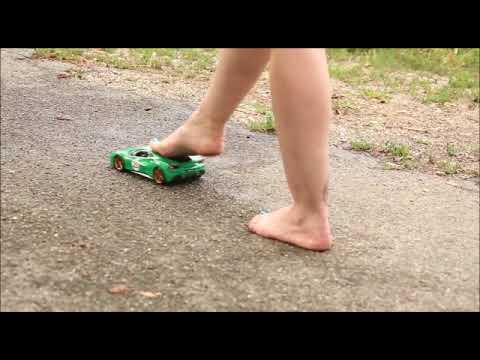 Riding green Ferrari toy model in bare feet