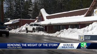 Residents clear off snow from roofs to avoid collapse as wet storm approaches