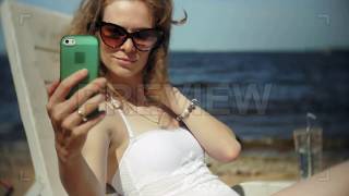 Taking Selfies While Sunbathing Stock Video screenshot 4