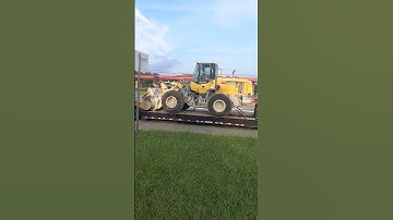 Beautiful white International big rig day cab lowboy trailer equipment load on move this AM