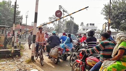 Crowd on railroad | gateman desperately trying to close railgate | level crossing