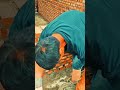 laying cement mortar on a red brick wall and building a sturdy structure at a construction site
