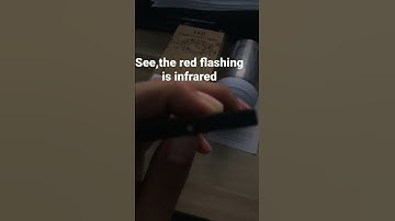 If it is an infrared remote control, you can see infrared light through your phone camera