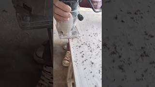 Hand laminate trimmer routing and profiling the raw edge of a wooden plank creating messy dust