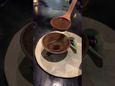 A chef at 80/20 Bangkok pouring soup