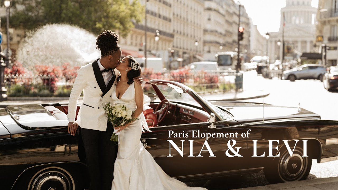 Bride and groom kiss beside a vintage convertible on a Paris street in warm afternoon light